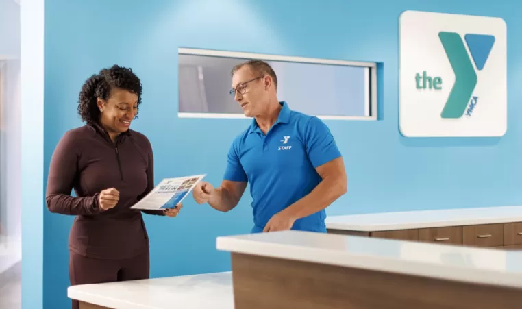 Woman checking in at the front desk of a gym