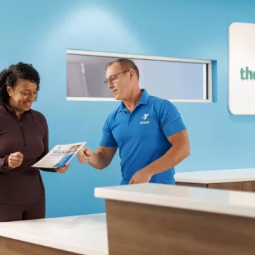 Woman checking in at the front desk of a gym