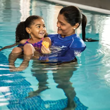 happy child taking a swim lesson with a YMCA instructor